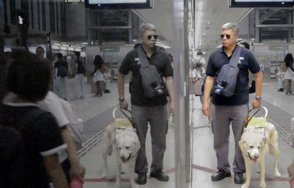 Mr Gary Lim and his guide dog Jordie waiting to enter a MRT cabin. Photo by: Jolynn Lee, Bibiana Inez Low