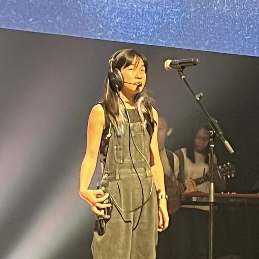 Brenda with a headset and microphone performing on stage