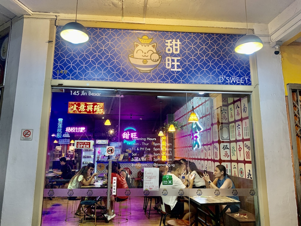 The entrance of Tian Wang dessert cafe offers a glimpse of neon lights and mahjong wall of the shop