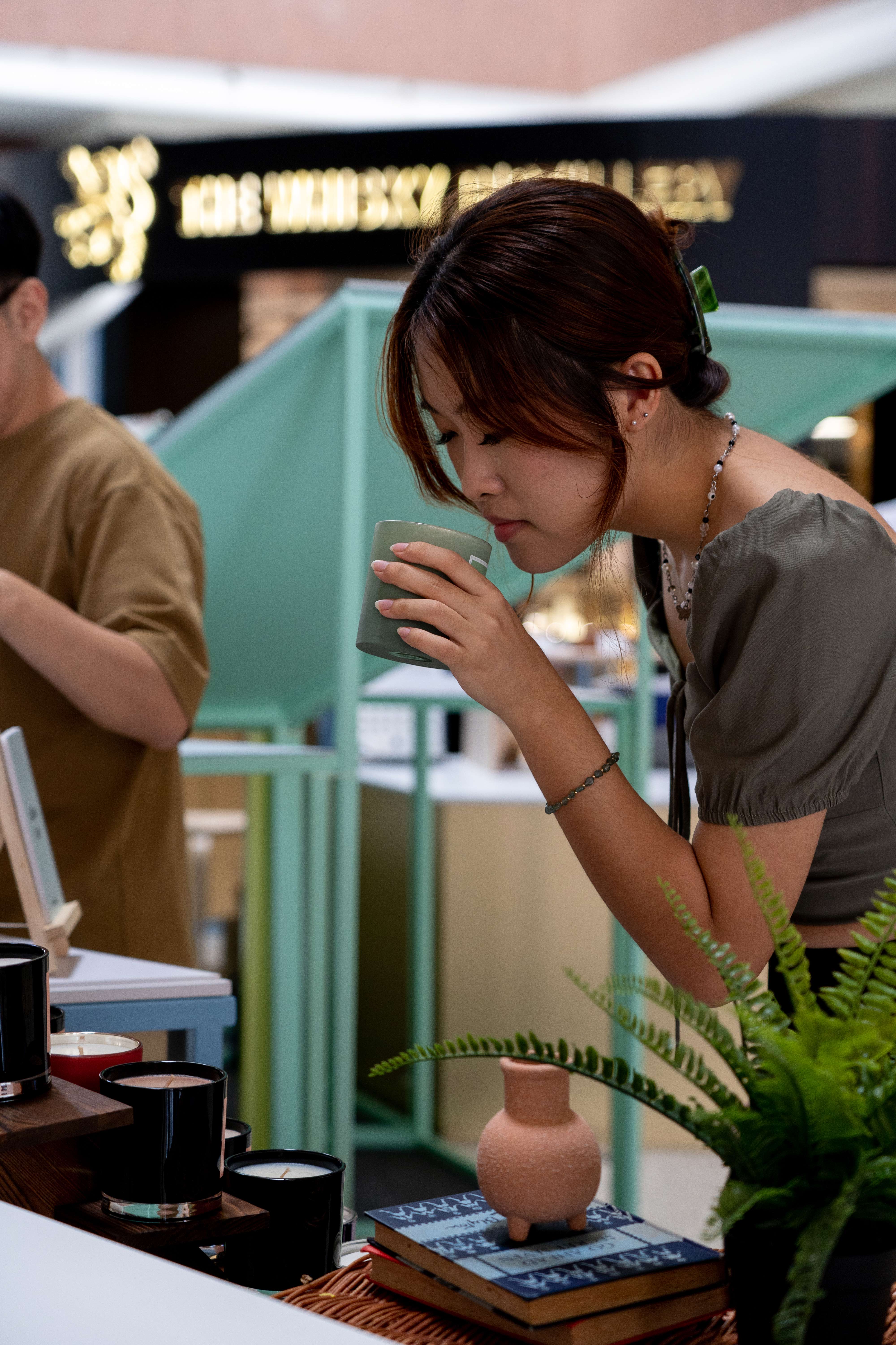 This photo shows Lead Designer Charlize Kon trying out a candle at Neighbourhood Socials