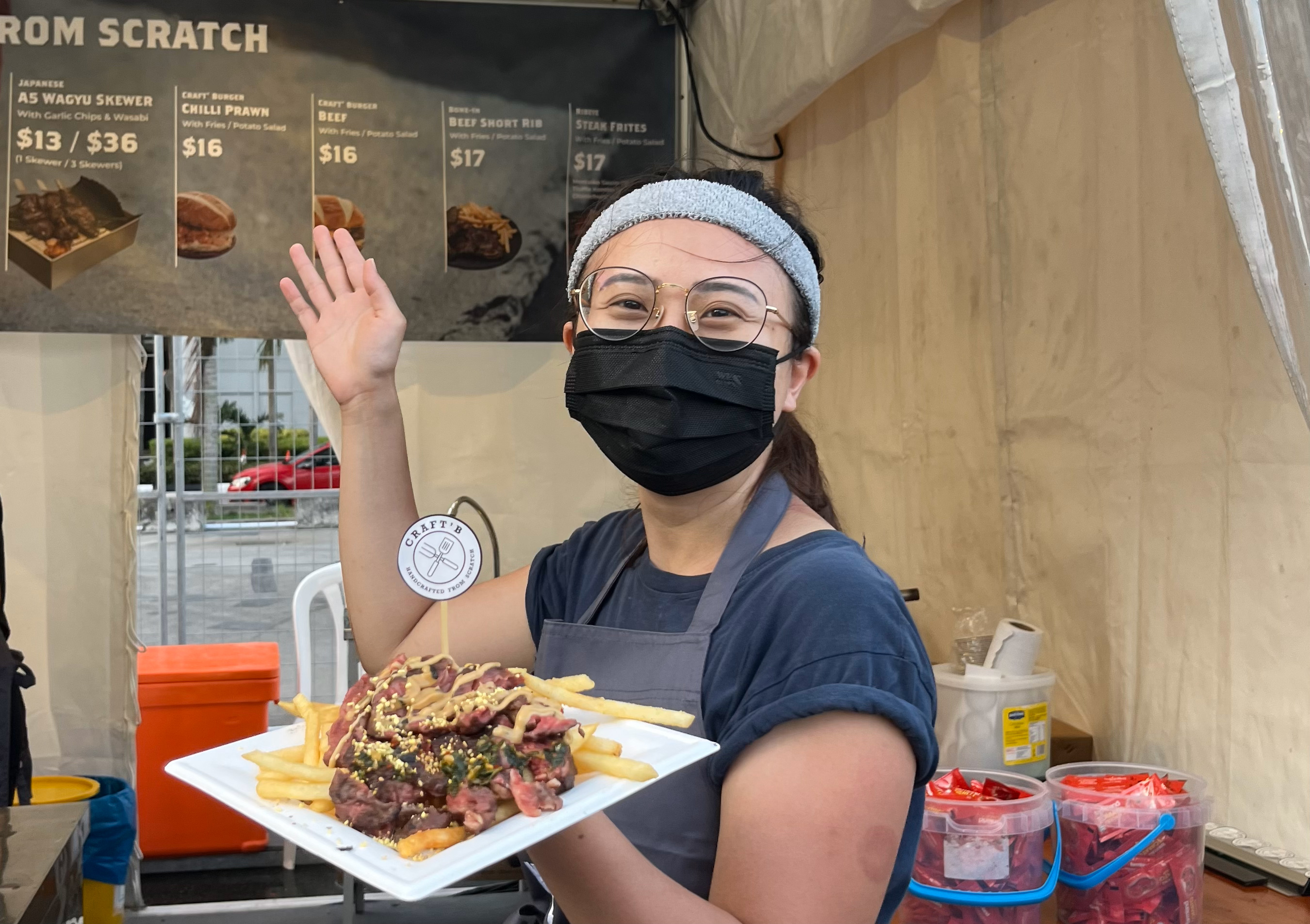 Co-founder of Craft'B, Sng Yu Jie posing in front of her storefront with the Grass Fed Ribeye with fries. 