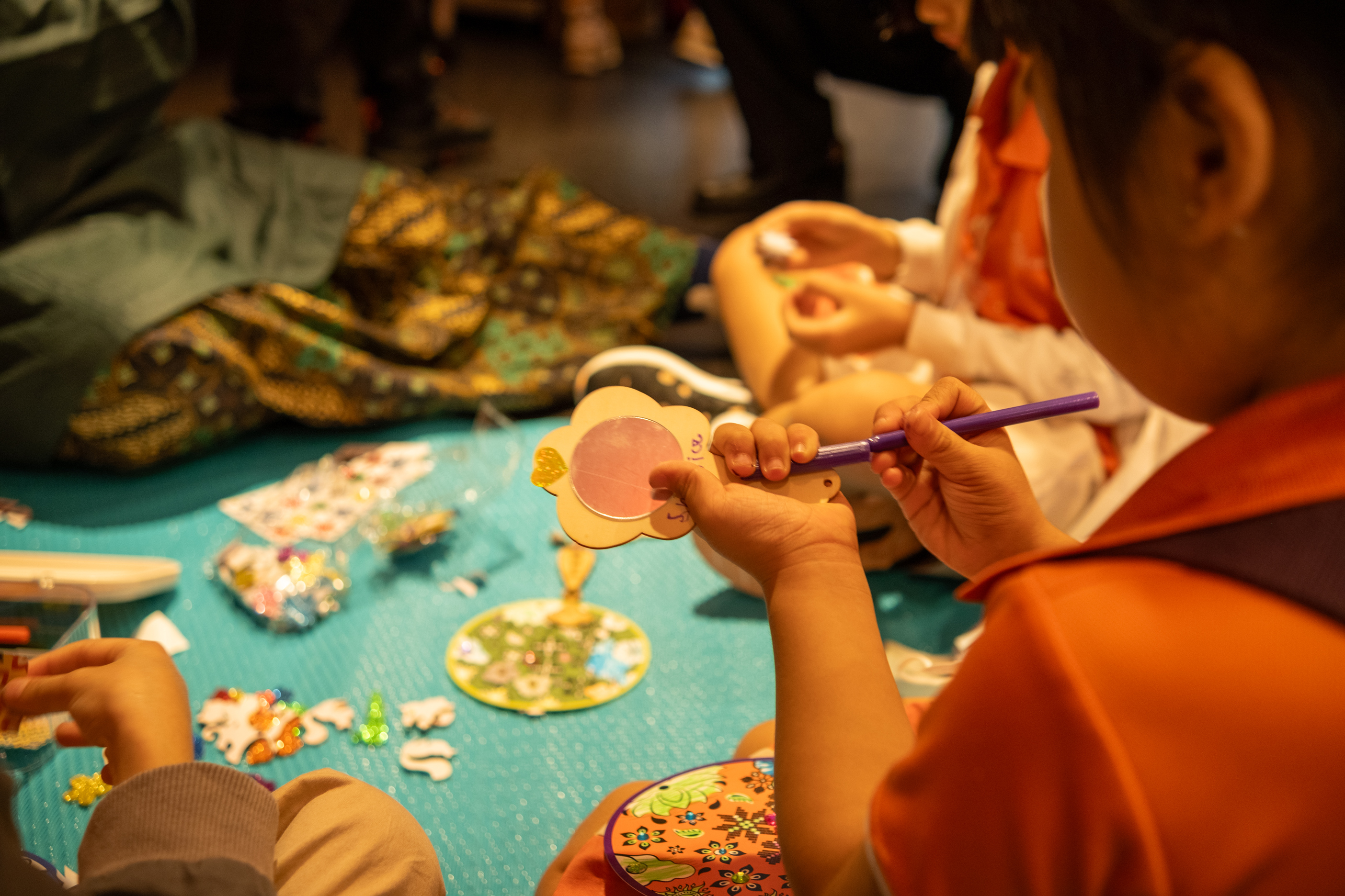 Participants using different stickers provided to decorate their own hand mirror. 