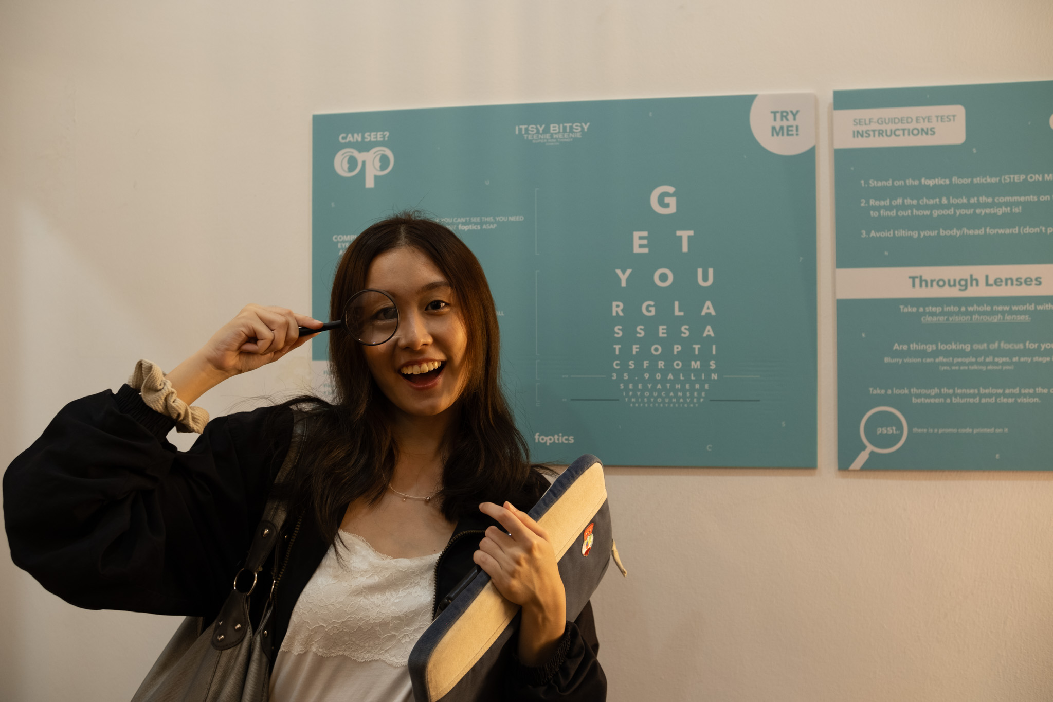 Our editor, Isabelle, posing with the free magnifying glass in front of the foptics showcase. Photo Credit: Josiah Lee