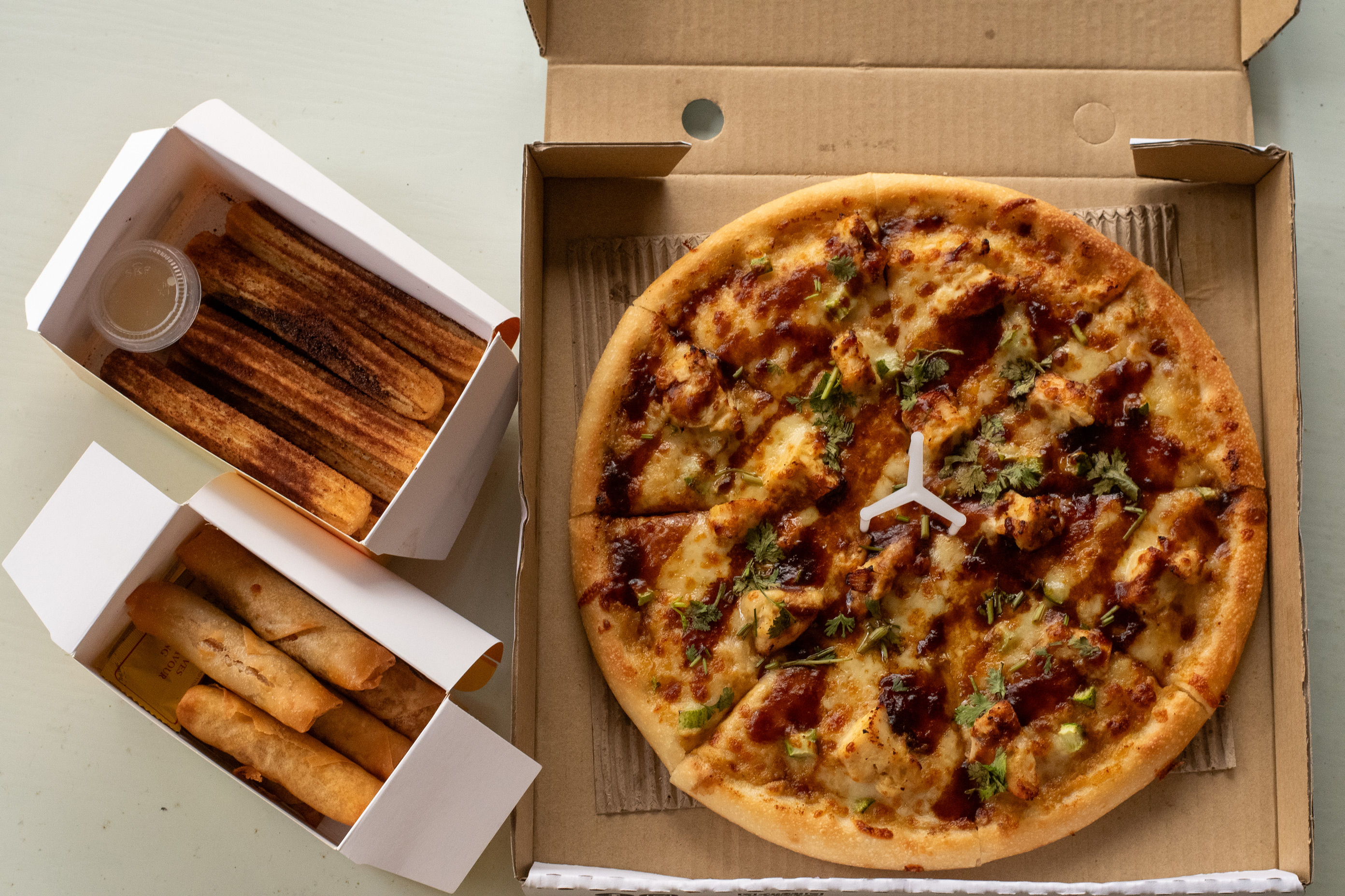 The National Day Menu items from Canadian Pizza. It shows the chicken rice pizza and milo churros.